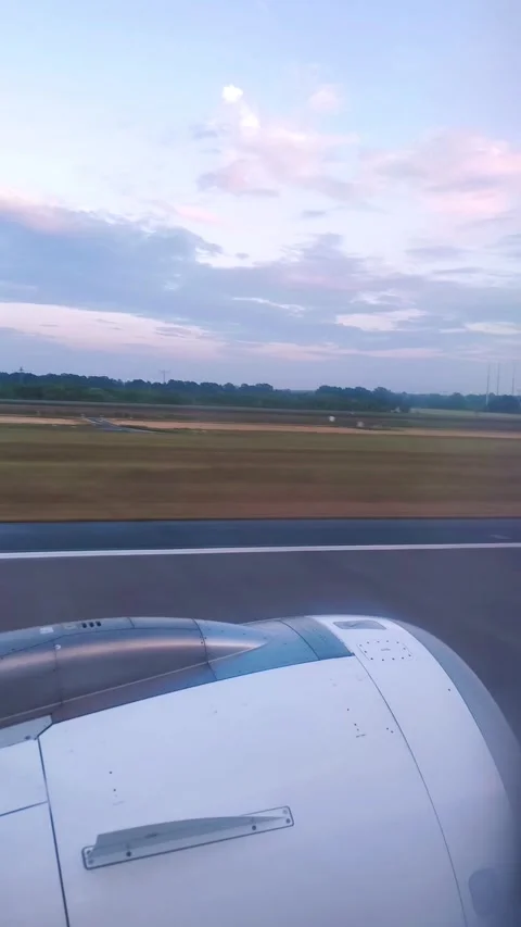 A view from the window of a plane taking off, showing the engine and runway at Stock Footage 326075652