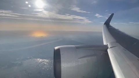 View from window plane of wing above crops at sunset Stock Footage 277289212