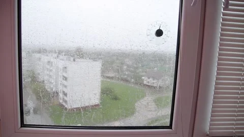 View from the window of raindrops on the glass and a mosquito net. Bad weather Stock Footage 295601319