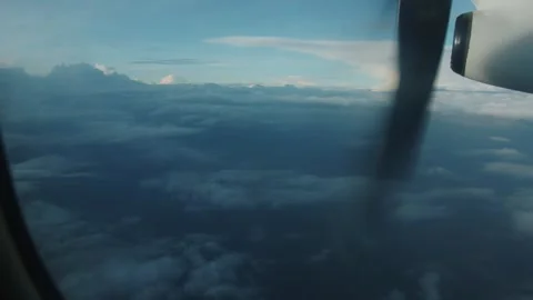 View from window of rotating propeller of an airplane flying above white fluffy Stock Footage 265448099