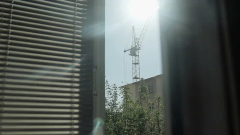 View from the window on the silhouette of a building tower crane and houses 動画素材 89776281