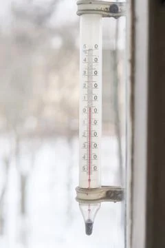A view at window thermometer which indicates plus five degree celsius scale Stock Photos