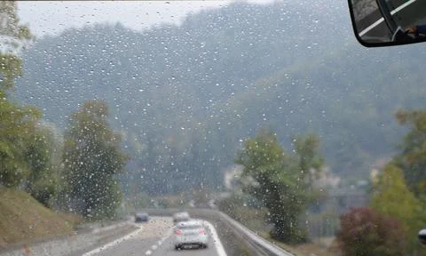 View from the windshield of a car in the rain. Mountain landscape and highw.. Stock Photos