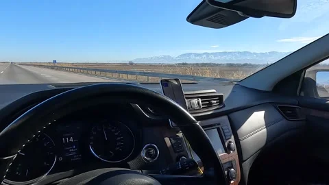 View from the windshield of the car on the road, steppe and mountains Video stock 230610759
