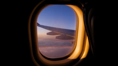 View Of Wing Of Airplane Flying Over Clouds With Scarlet Sunset Sky From Window Stock Footage 126113043