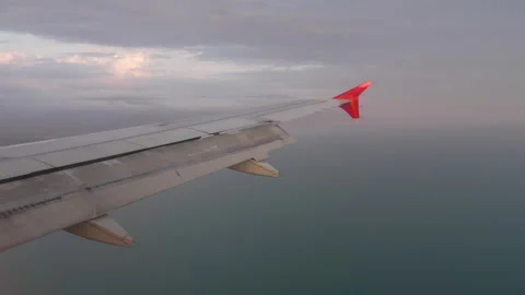 View of the wing of an airplane flying over the ocean Video stock 274361914