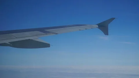 A view of the wing of an airplane through a window against a background of .. Stock Footage 73653978