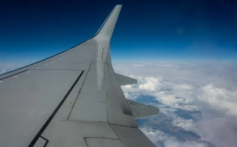 View of the wing and clouds in the sky from the window of the plane. Foto stock