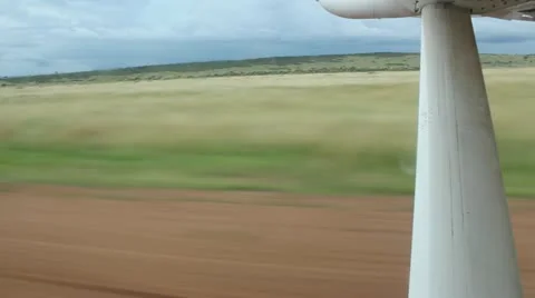 View of  Wing and Takeoff from Dirt Airstrip in Africa   (HD) Stock Footage 12402713