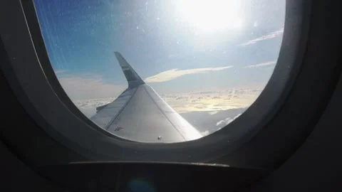 View of a wing through a window, flying over clouds. Stock Footage 345357353