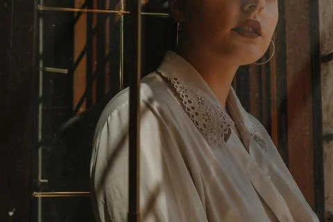 View of woman in white button down shirt through window pane of glass Stock Photos