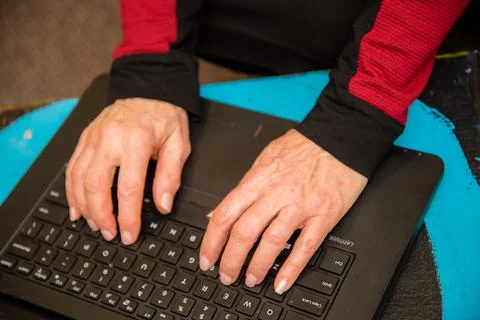 View of woman's hands typing on a black keyboard laptop. Stock Photos