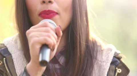View of woman's mouth with red lipstick, smiling and singing with microphone Stock Footage 59556633