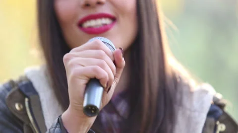 View of woman's mouth with red lipstick, smiling and singing with microphone Stock Footage 59556637