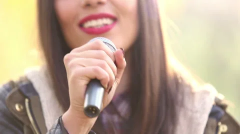 View of woman's mouth with red lipstick, smiling and singing with microphone Stock Footage 59556638