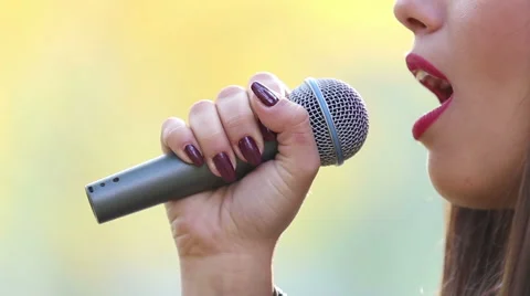 View of woman's mouth with red lipstick, smiling and singing with microphone Stock Footage 59556653