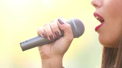 View of woman's mouth with red lipstick, smiling and singing with microphone Stock Footage 59556654
