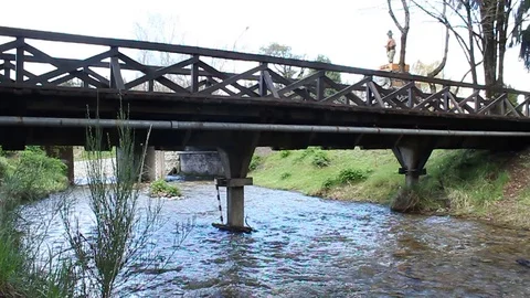 View of a wooden bridge from a shore Stockbeeldmateriaal 128460341