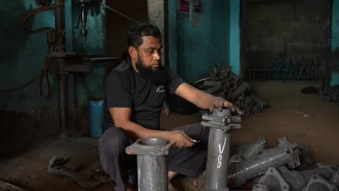 View of a worker assembling metal engine parts, Bangladesh. Video stock 334950303