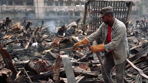 View of a worker cutting metal debris in a burnt area, Bangladesh. Stock Footage 335600186