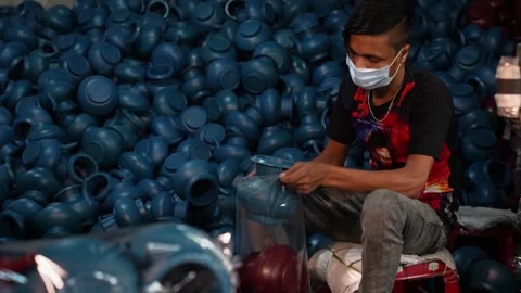 View of a worker packing blue plastic pots in Bogura, Bangladesh. Stock Footage 336425340