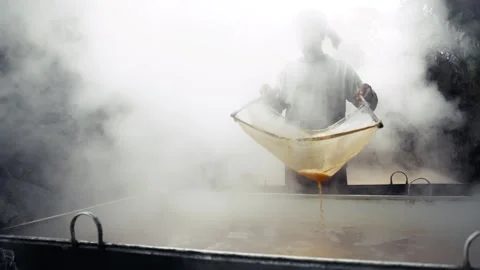 View of a worker stirring boiling molasses in thick steam, Bangladesh. Vídeo Stock 335653009