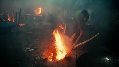 View of a worker tending to a fire in a workshop, Bangladesh. Stockbeeldmateriaal 336426701