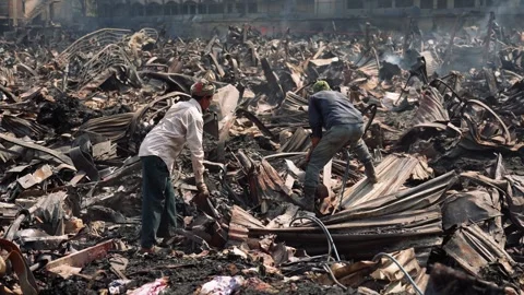 View of workers amidst charred debris after a fire, Bangladesh. Stock Footage 335600114