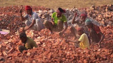 View of workers breaking bricks with hammers in a yard, Bangladesh. Video stock 334980837
