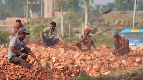 View of workers breaking red bricks with hammers, Bangladesh. 動画素材 334981059