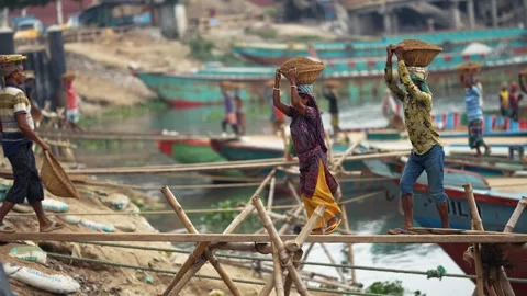 View of workers carrying baskets on planks in Aminbazar, Bangladesh. Video stock 334993455