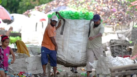 View of workers carrying a large bag of plastic bottles, Bangladesh. Stock Footage 336424389