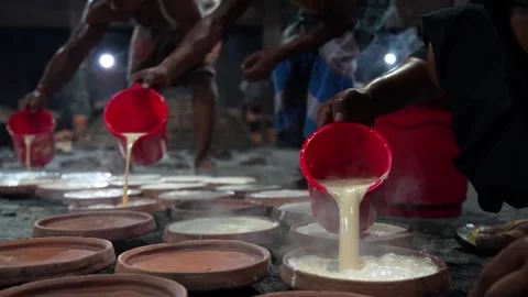 View of workers pouring curd into clay pots in Bogura, Bangladesh. Stock Footage 336425841