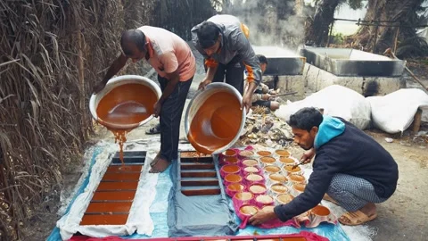 View of workers pouring molasses into molds in Natore, Bangladesh. Stockbeeldmateriaal 335651833