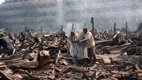 View of workers searching through fire debris in Dhaka, Bangladesh. Stock Footage 335600142