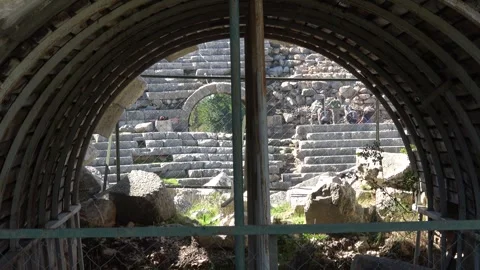 View on workers through ancient vaulted entrance of Letoon theater Vidéo 348679975