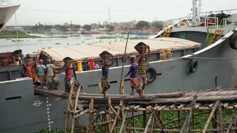 View of workers unloading cargo from a ship in Aminbazar, Bangladesh. Stock Footage 334995798