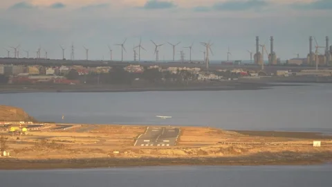 View of working wind turbines and simultaneously starting and landing airpl.. Stock Footage 265257636