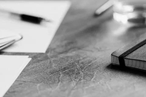 View of the workplace. Open notebook over table. Black and white photography. Stock Photos