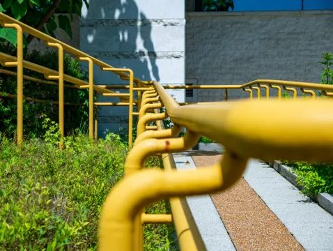 View on a yellow railing of a sidewalk Stock Photos