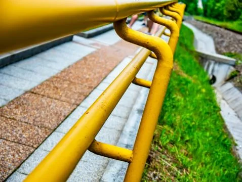 View on a yellow railing of a sidewalk Stock Photos