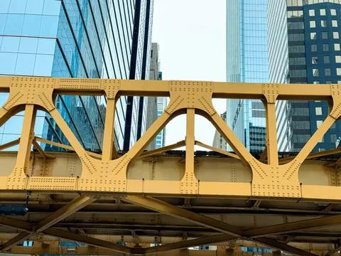 View of a yellow train bridge over railroad tracks in city Stock Photos