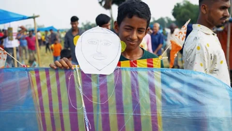 View of a young boy holding a large colorful kite, Bangladesh. Stock Footage 335015280