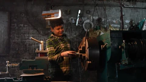 View of a young boy working on a lathe machine, Bangladesh. Stock Footage 335584686
