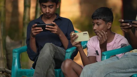 View of young boys playing games on smartphones in Bogura, Bangladesh. Video stock 335025546