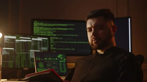 View of a young dark-haired man with a serious look. A male programmer sits in Stock Footage 236564086