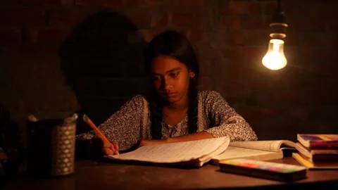View of a young girl studying under a light bulb, Bangladesh. Stockbeeldmateriaal 335584816