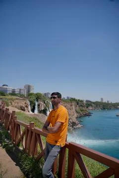 A view of a young man posing and a view of the sea and a waterfall Stock Photos
