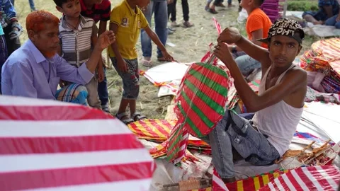 View of a young man preparing a colorful kite in Bogura, Bangladesh. Video stock 335012623