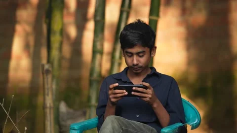 View of a young man using a smartphone outdoors, Bangladesh. Video stock 335025365